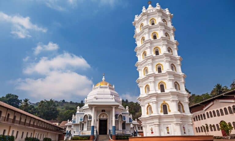 The iconic seven-story white Deepstambha (lamp tower) and Shri Mangeshi Temple in Ponda, Goa, showcasing Goan Hindu architecture.