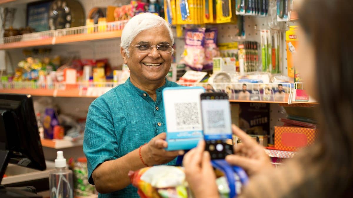 Traveler using UPI for foreigners to pay via QR code at an Indian market.